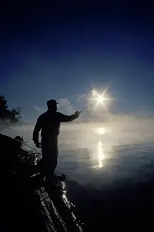 Mark Carlson Prints: Canada, Ontario, Silhouette of fisherman casting a line into lake on a summer sunrise