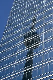 Canada, Ontario, Toronto. Reflection of CN Tower on glass side of skyscraper