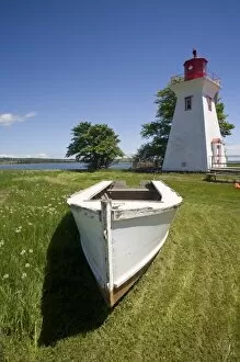 Canada, Prince Edward Island, Victoria. Lighthouse with maple leaf, and rescue boat
