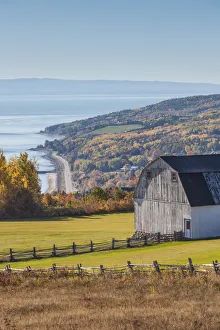 Canada, Quebec, Sainte Irenee. Elevated view of farm and St. Lawrence River
