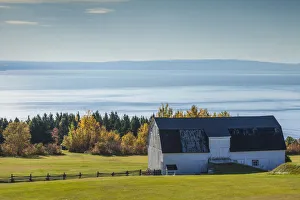 Canada, Quebec, Sainte Irenee. Elevated view of farm and St. Lawrence River