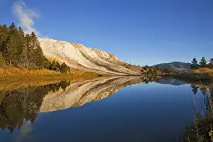 Canary Springs Terrace reflects in small pond at the Mammoth Hot Springs area in