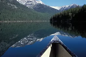 canoe on a placid lake along the eastern side of Glacier National Park, Montana