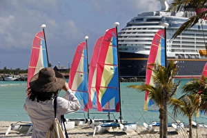 Images Dated 25th March 2012: Caribbean, Bahamas, Castaway Cay. Woman taking picture at Castaway Cay