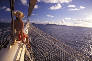 Passenger Prints: Caribbean. Passenger sitting on bow of Star Clipper (MR)