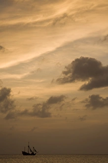 Images Dated 12th April 2007: Cayman Islands, Grand Cayman Island, Setting sun silhouettes yacht sailing through