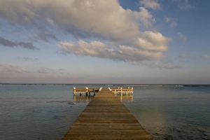 Images Dated 17th April 2007: Cayman Islands, Little Cayman Island, Setting sun lights wooden boat pier in Caribbean