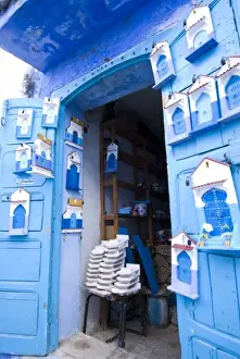 Plaque Prints: Chefchaouen Morocco an artists shop selling painted wooden door plaques in