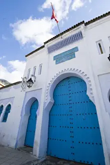 Riff Mountains Prints: Chefchaouen Morocco blue door and red flag on a building in the medina