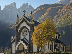 Dolomite Prints: Chiesa di San Sebastiano in Falcade in Val Biois, in the background the Focobon mountain
