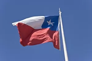 Chile, Patagonia, Punta Arenas. Chilean flag waves against blue sky