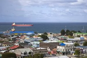 Chile, Patagonia, Punta Arenas. A large tanker off the coast with city in foreground