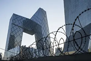 Futuristic Prints: China, Beijing, Barbed wire surrounds perimeter of gleaming steel and glass CCTV