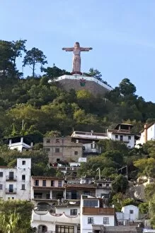 A Christ statue sits above homes built on the hillside at Taxco in the State of Guerrero, Mexico
