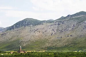A church on the plain dominated by the Kastrat Shkrel mountains near Koplik and the