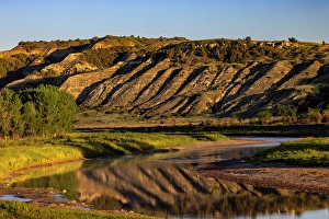 Prints of Cliffs reflection in the Little Missouri River at sunrise in Theodore Roosevelt National Park, North Dakota, USA. (Editorial Use Only) Images Dated 2024 September: Cliffs reflection in the Little Missouri River at sunrise in Theodore Roosevelt National Park