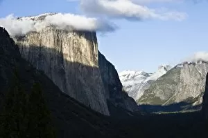 Clouds form around the peak of El Capitan as afternoon light paints Yosemite Valley