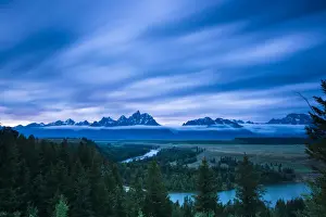 Images Dated 21st July 2008: Clouds illuminate with red light above the Grand Teton mountains seen from the Snake