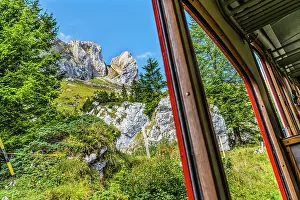 Colorful cogwheel rail car climbing Mount Pilatus, Lucerne, Switzerland