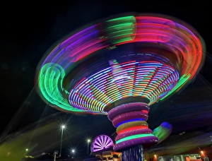 Images Dated 3rd September 2024: Colorful motion blur of spinning ride at a carnival