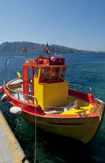 Bottom Prints: Colorful yellow fishing boat in fishing village at bottom of Oia in Santorini in