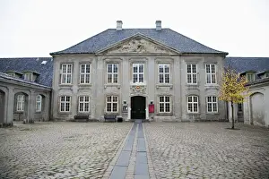 Inti St Clair Prints: Copenhagen, Denmark - The facade of an old building with a brick courtyard in front