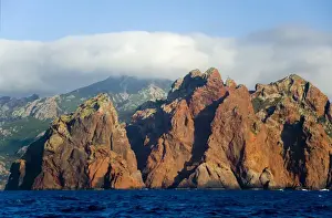 Stark Prints: Corsica. France. Europe. Pinnacles of red granite at rise out of the sea at Punta Muchillina