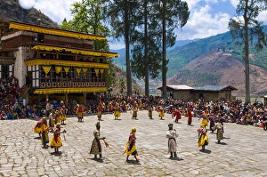 Images Dated 7th April 2009: Costumed dancers at religious festivity with many visitors, Paro Tsechu, Bhutan