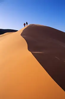 James Kay Prints: A couple walks along the crest of a golden sand dune in Coral Pink Sand Dunes State Park