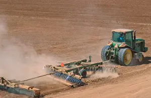 Tractor Prints: Crawler type tractor discing a field in preparation for planting in the Central Valley