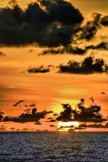 Cloudscape Prints: The crimson light of the setting sun reflects a red glow on the beach at Pererenan Beach