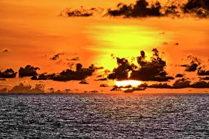 Cloudscape Prints: The crimson light of the setting sun reflects a red glow on the beach at Pererenan Beach