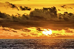 Cloudscape Prints: The crimson light of the setting sun reflects a red glow on the beach at Pererenan Beach