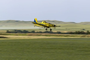 Crop Duster airplane spraying flax filed for grasshoppers near Mott, North Dakota, USA