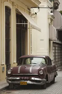 Communist Prints: Cuba, Havana, Havana Vieja, morning view of Old Havana street with 1950s-era US car