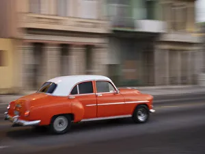 Images Dated 29th January 2022: Cuba, Havana, Havana Vieja, UNESCO World Heritage Site, classic red car in motion