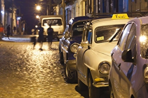 Images Dated 13th March 2012: Cuba, Sancti Spiritus Province, Trinidad, taxis on Calle Antonio Maceo, dusk