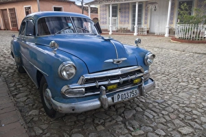 Spanish Speaking Prints: Cuba, Trinidad. Blue taxi parked on cobblestones