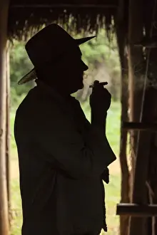 Tobacco Prints: Cuba, Vinales. Silhouette of a tobacco farmer smoking a cigar