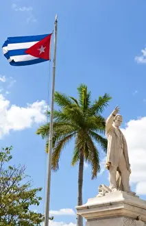 Hero Prints: Cuban flag and statue in center of town of Jose Marti hero in CVienfuegos Cuba