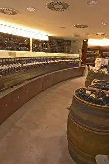 Seller Prints: A curved display of bottles and a barrel used to present bottles The Lavinia wine shop in Paris