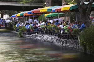 Diners and visitors in motion at outdoor cafe, River Walk, and San Antonio River