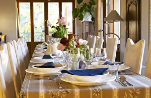 The dining room table decorated and set with flowers and decorative vegetables for dinner guests