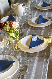 The dining room table set with flowers and decorative vegetables for dinner guests