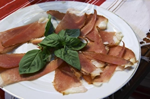 Basil Prints: Dried dry cured ham with basil leaves on a white plate