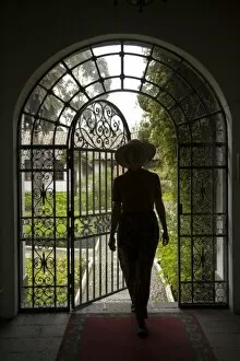 Ecuador, Lasso, woman in arch with wrought-iron door to garden, Hacienda La Cienega (MR)