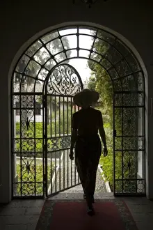 Ecuador, Lasso, woman in arch with wrought-iron door to garden, Hacienda La Cienega (MR)