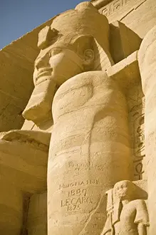 Egypt, Aswan. 19th century grafitti on Colossus of Ramses II at entrance of Abu Simbel