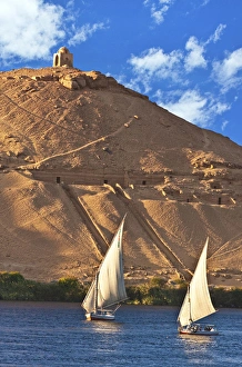 Egypt, Aswan, Nile River, Felucca sailboats, temple ruins and the large sand dunes