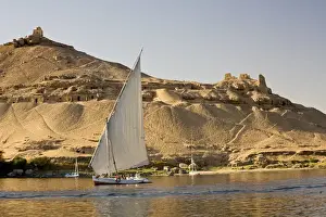 Felucca Prints: EGYPT, Aswan. The rock-hewn Tombs of the Nobles pock mark the West bank of the Nile